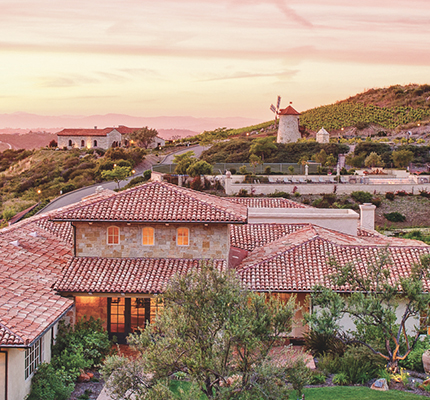 a group of houses with a windmill in the background