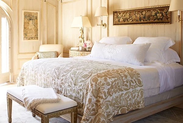 a bed with a white blanket and a bench
