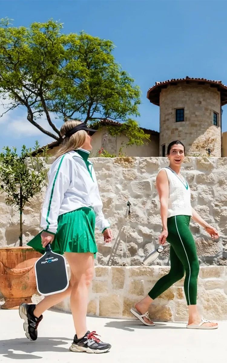 a group of women in matching outfits walking outside