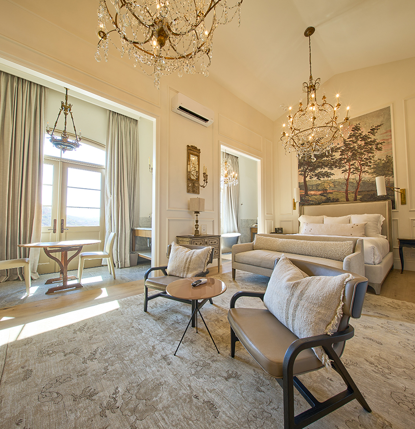 a room with a bed couch and chandelier