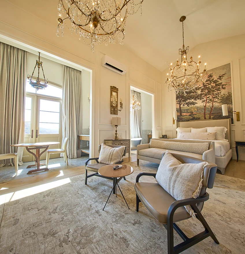 a room with a bed couch and chandelier