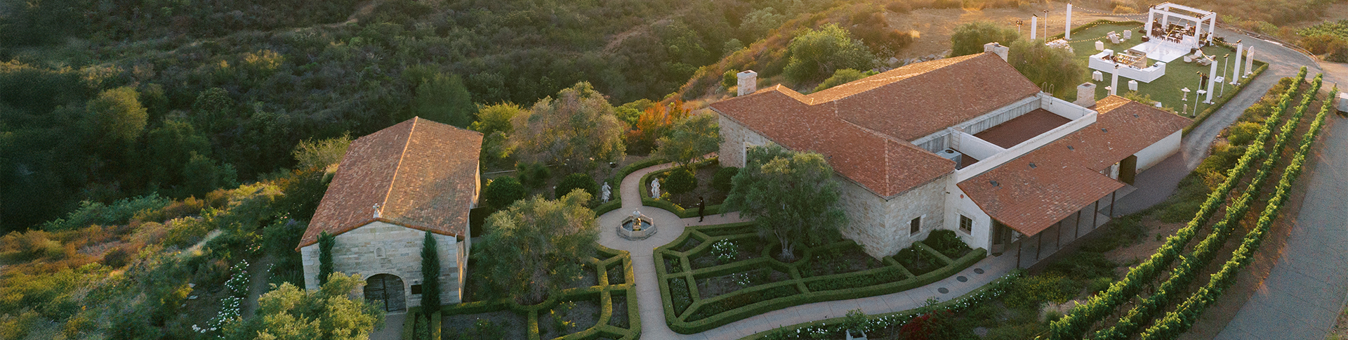 a garden with a fountain and a building