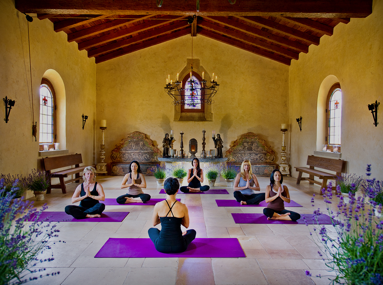 a group of people sitting in a room with a group of people in yoga mats