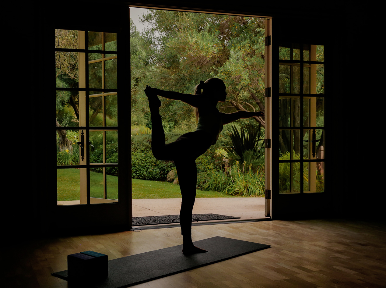 a woman doing yoga in front of a door