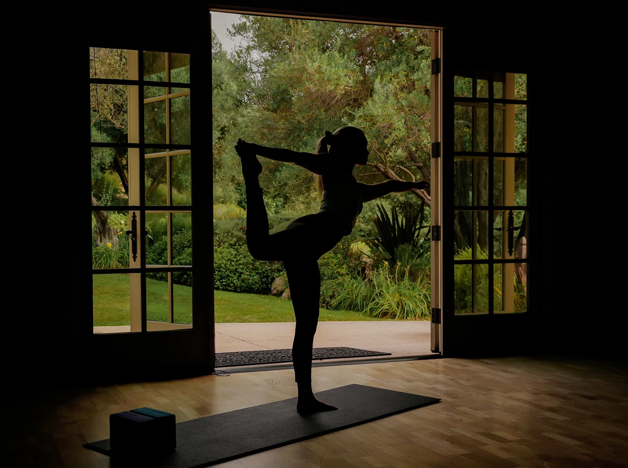 a woman doing yoga in front of a door