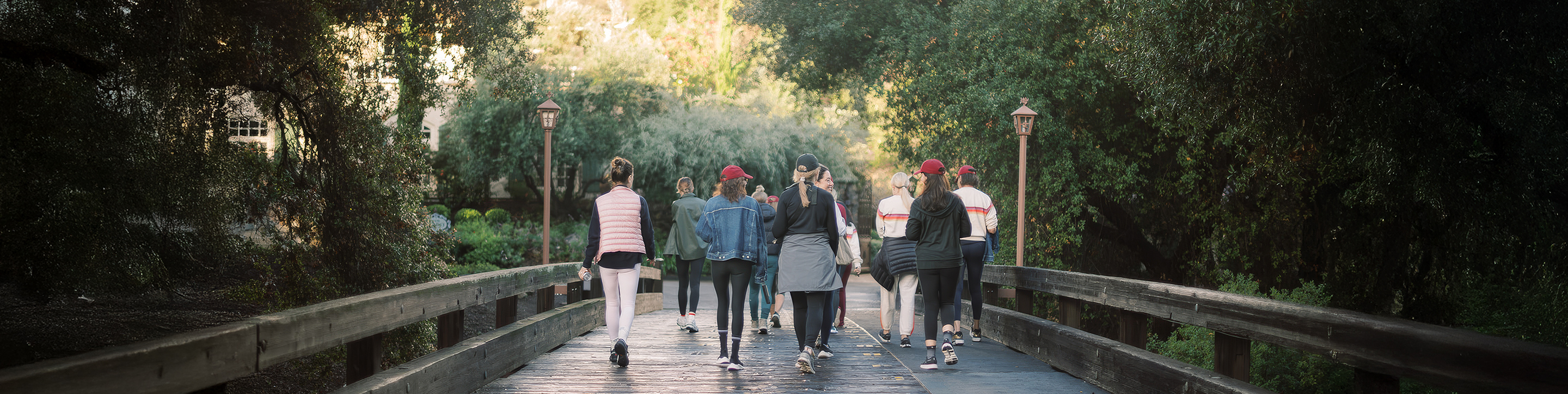 a group of people walking on a wooden walkway