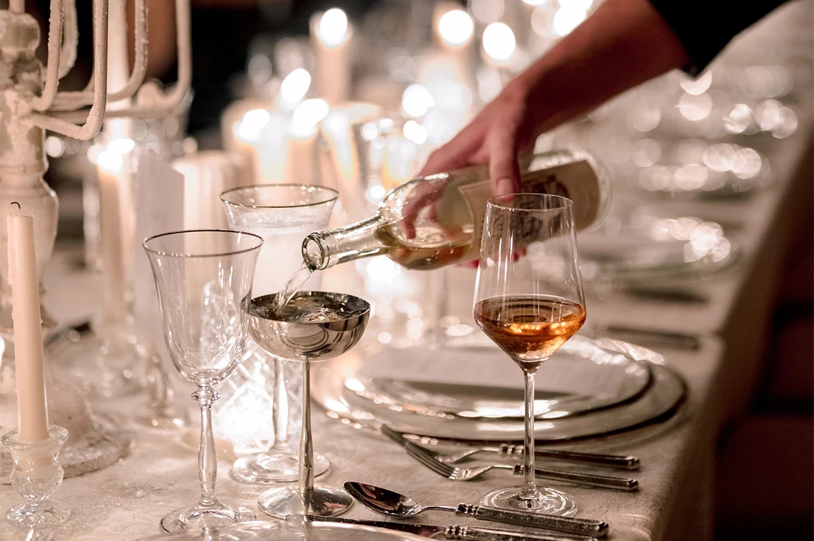 a person pouring wine into a glass