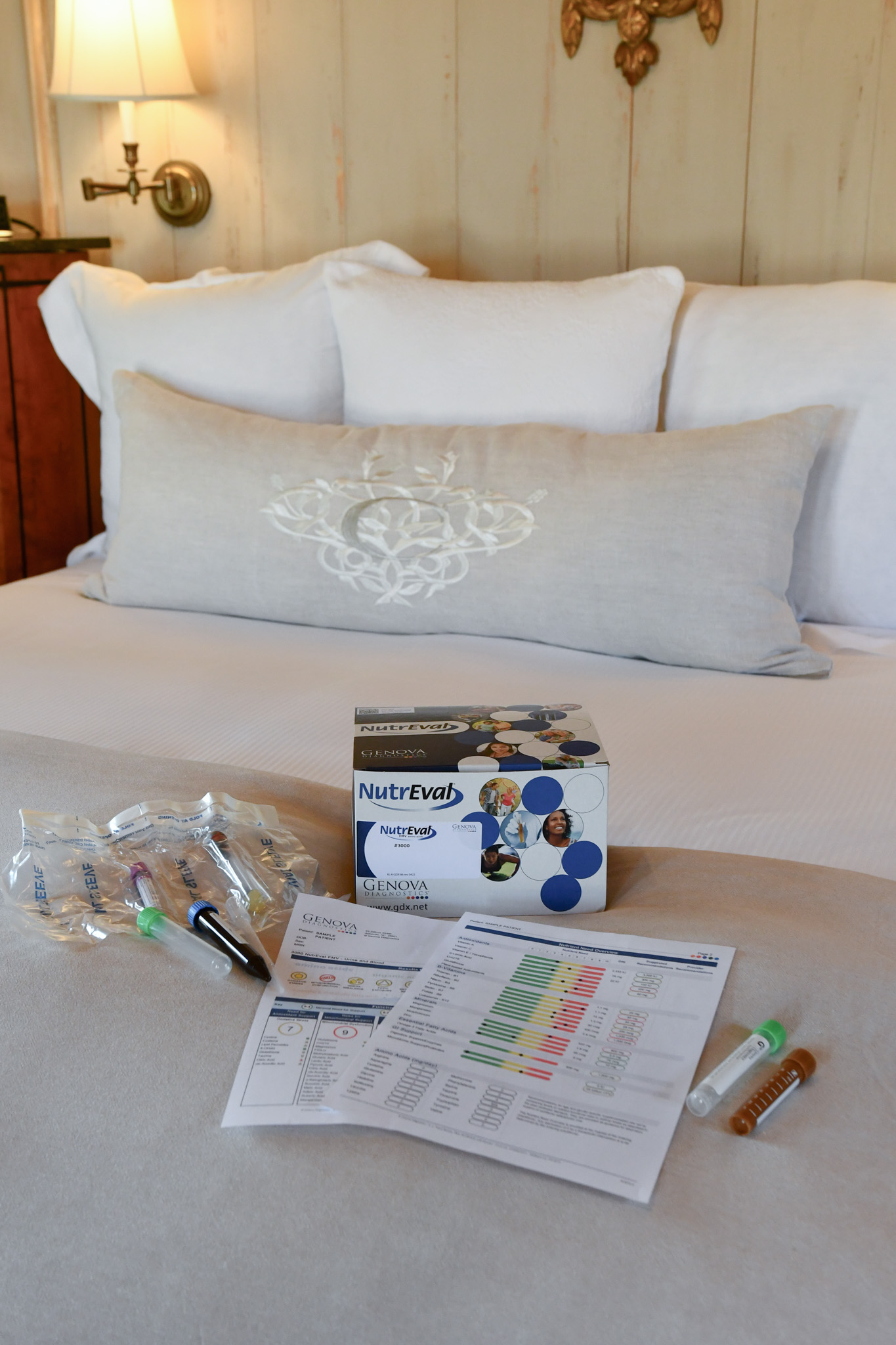 a bed with a box of syringes and a box of pills