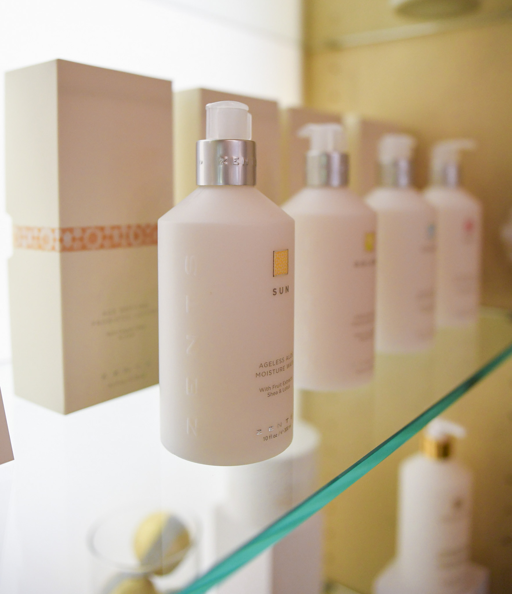 a group of white bottles on a glass shelf