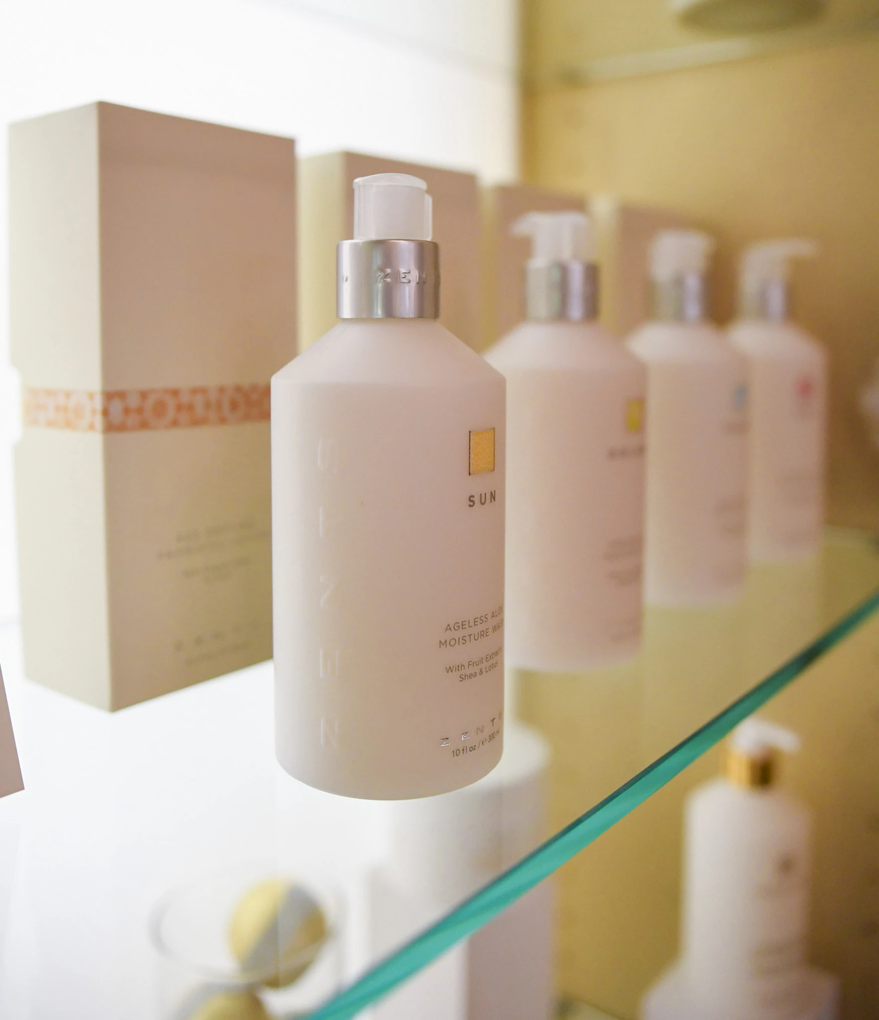 a group of white bottles on a glass shelf