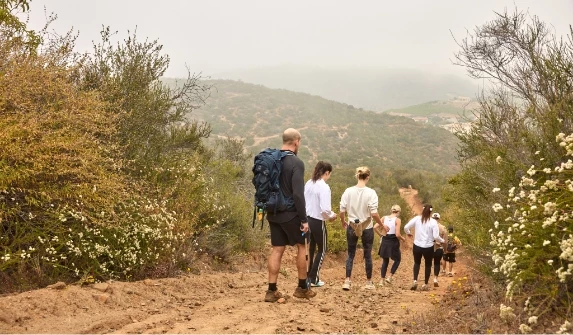 a group of people walking on a dirt path