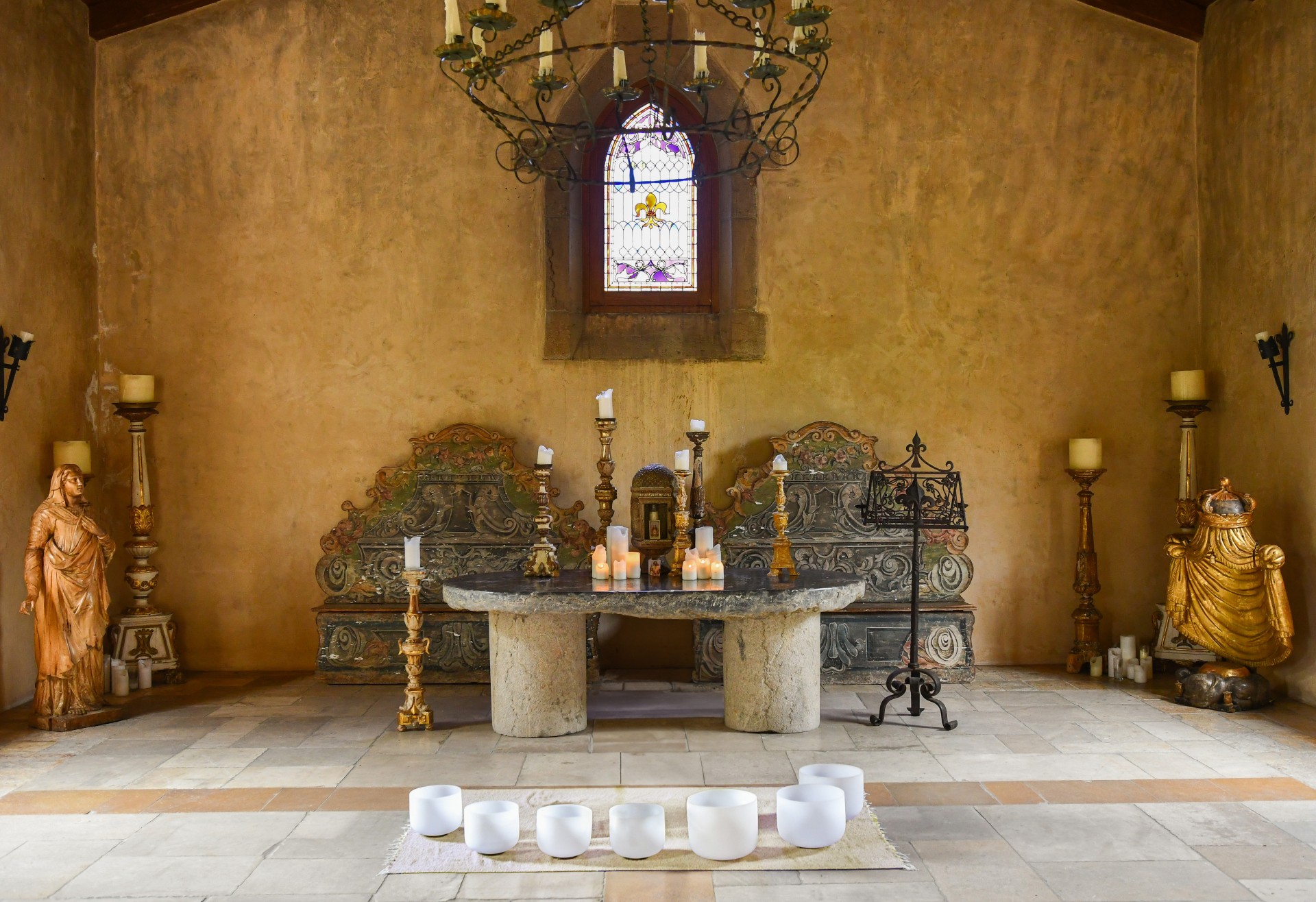 a room with a table with candles and benches