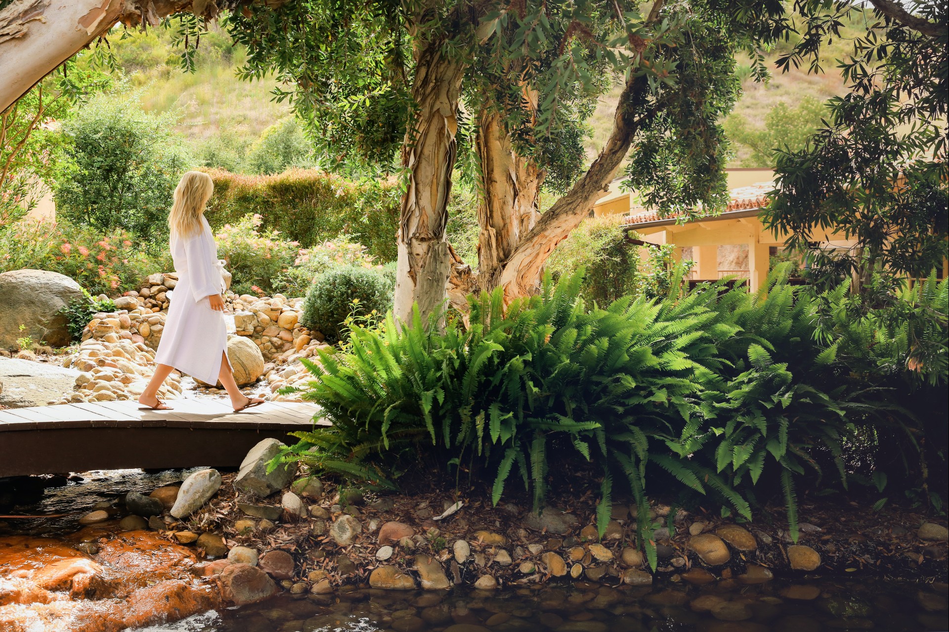 a woman walking on a bridge near a river