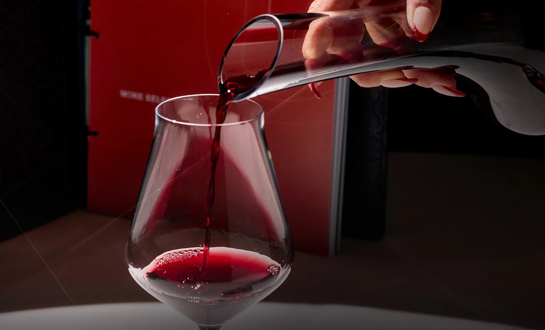 a person pouring a glass of wine