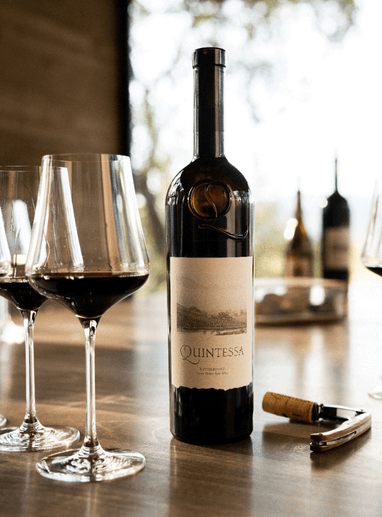 a bottle of wine next to wine glasses