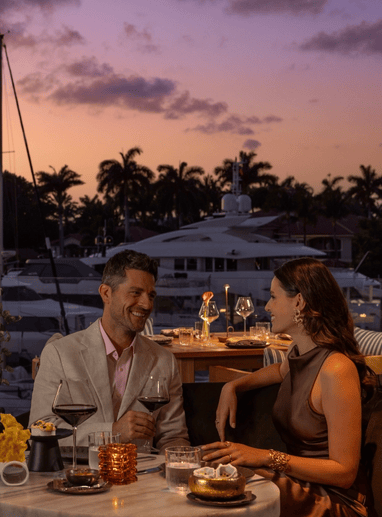 a man and woman sitting at a table with drinks