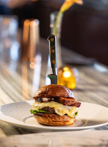 a burger with a knife stuck in the top