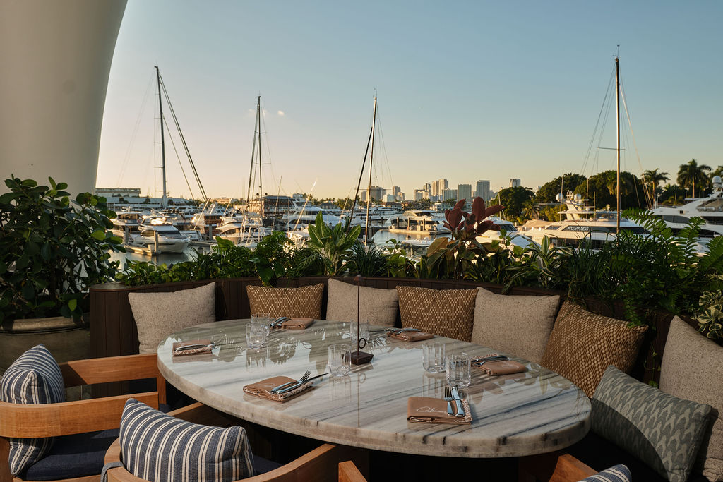 a table with chairs and a view of boats and city