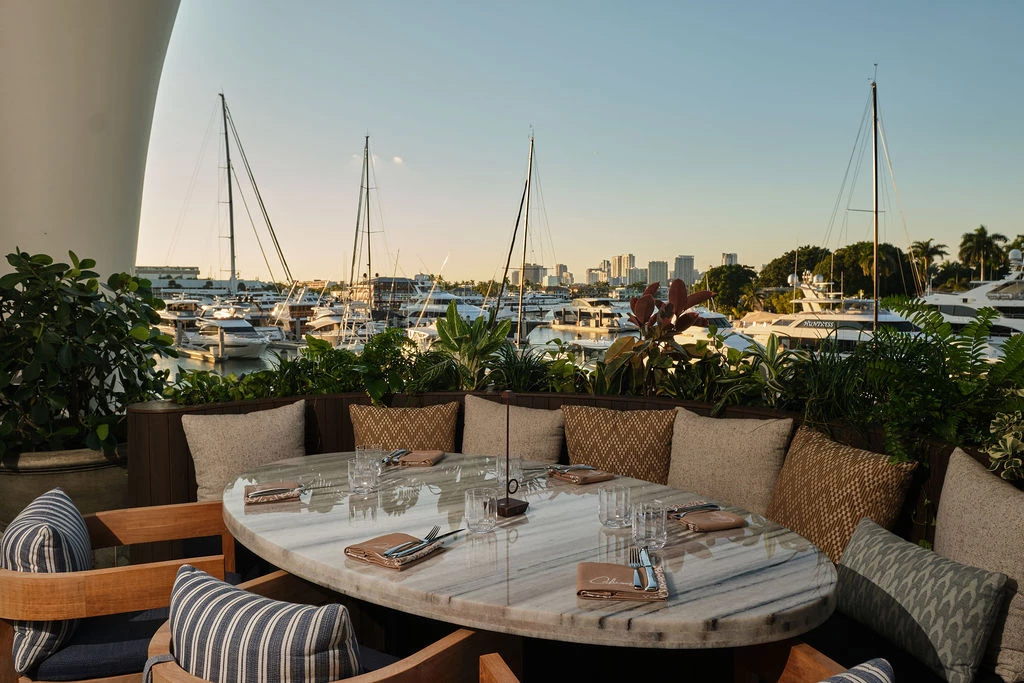 a table with chairs and a view of boats and city
