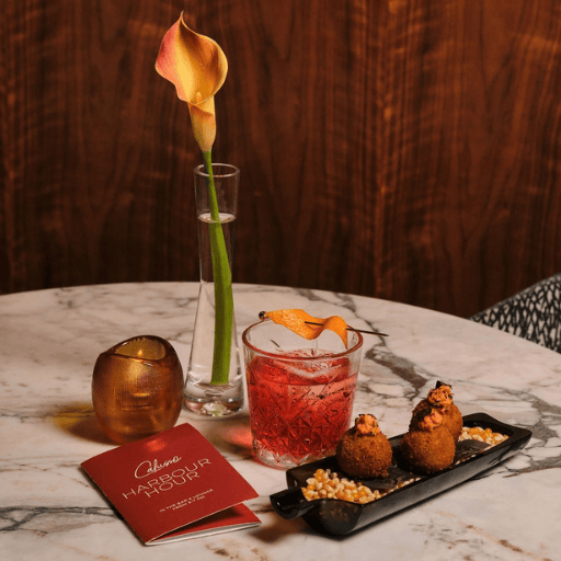 a table with a drink and a flower on it