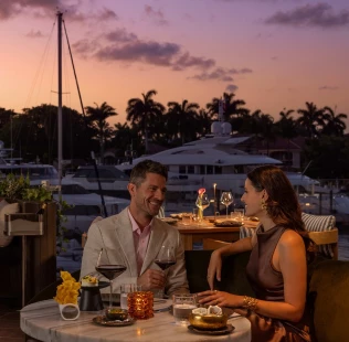 a man and woman sitting at a table with drinks