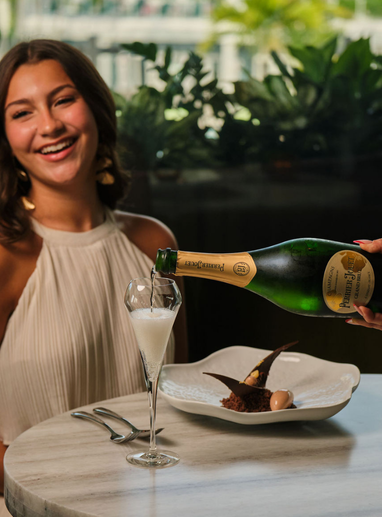a woman pouring a drink into a glass