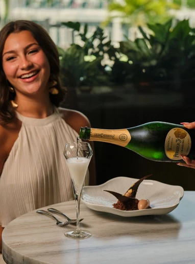 a woman pouring a drink into a glass