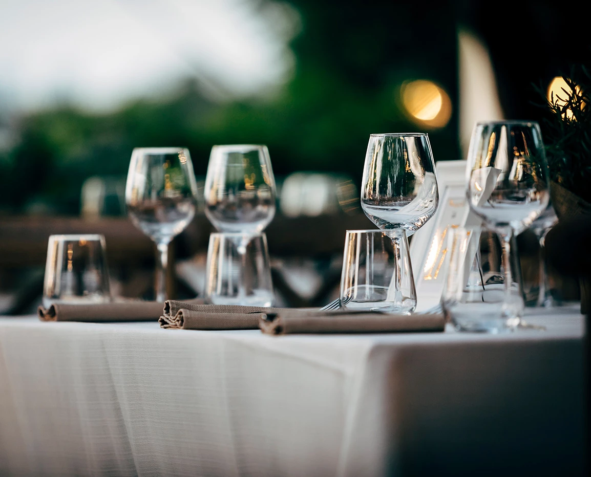 a table with wine glasses and napkins