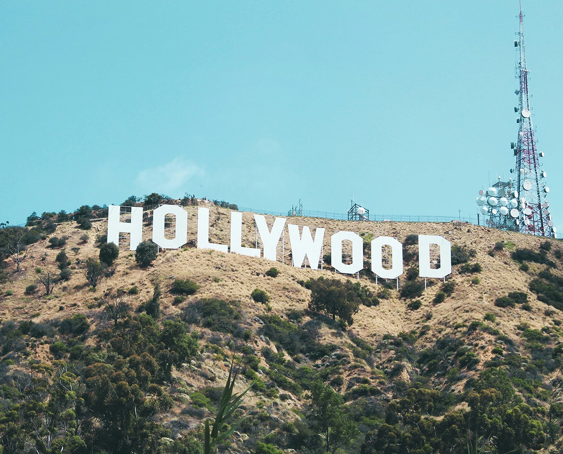 a sign on a hill with Hollywood Sign in the background