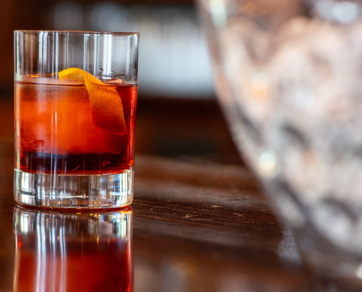 a glass with a drink and a slice of orange peel