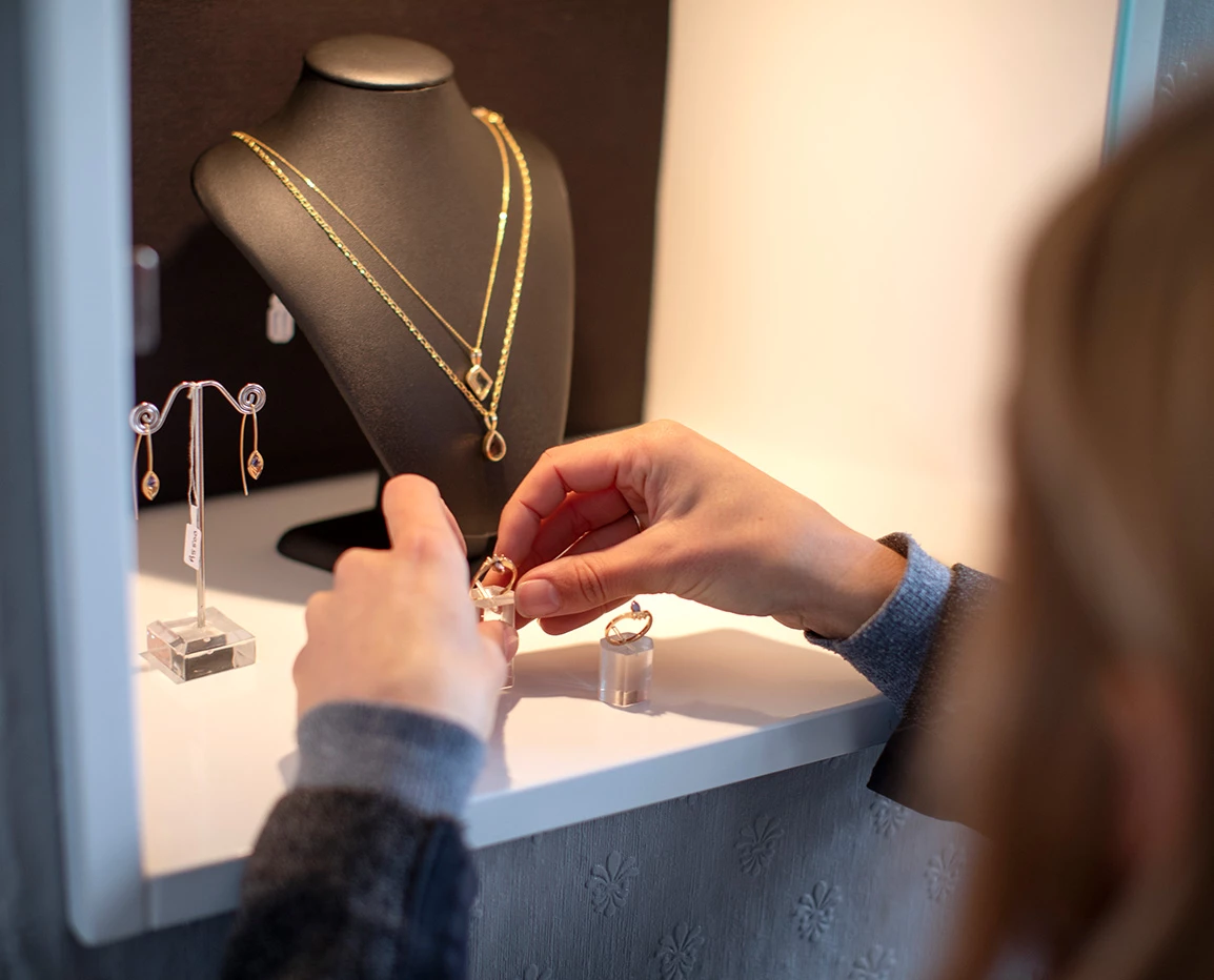 a person looking at a necklace and earrings