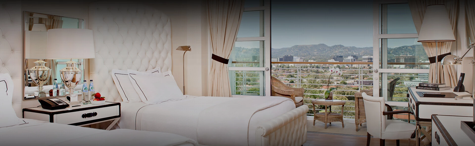 a bed with a chair and a window with a view of the city