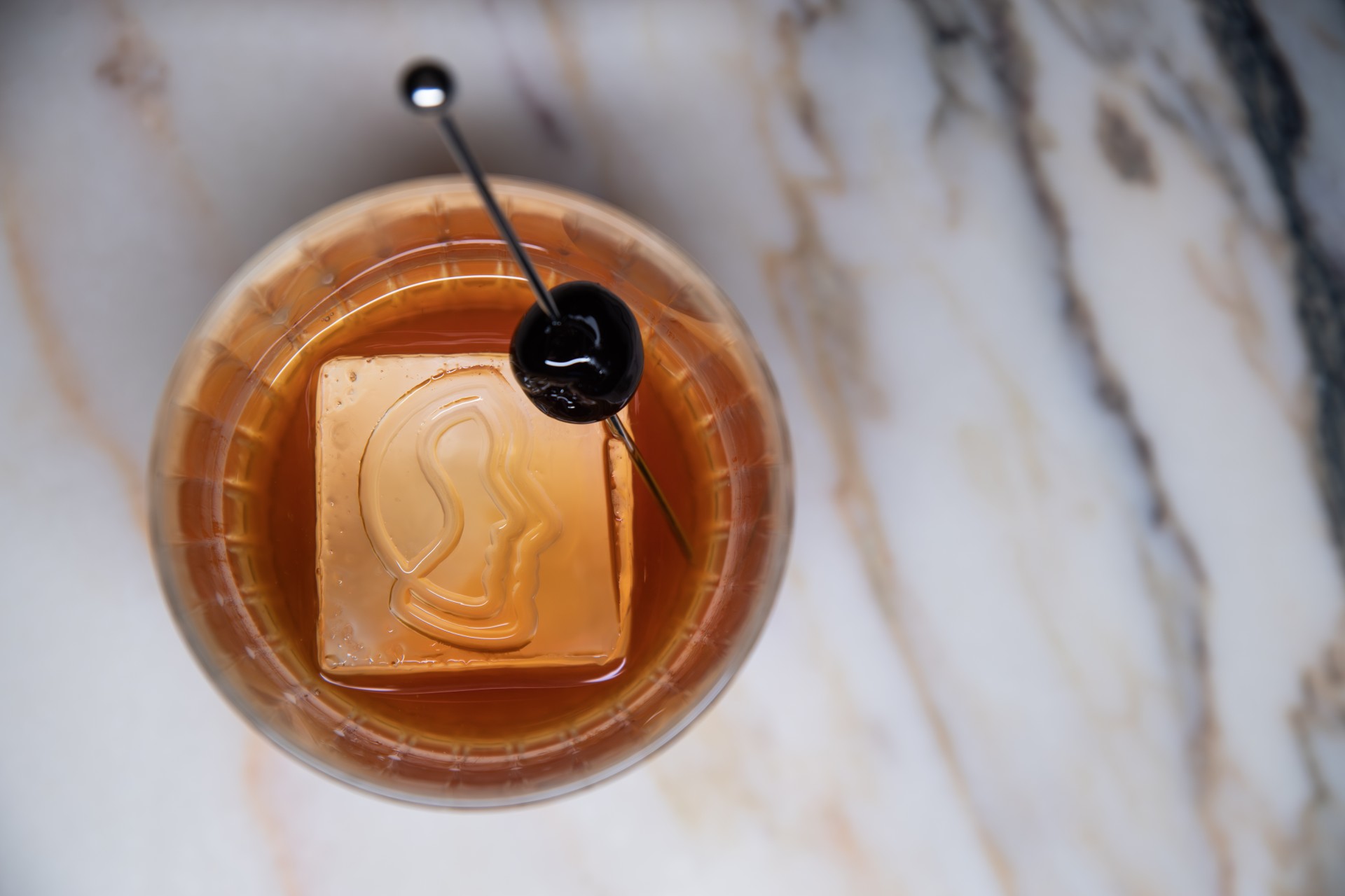 a glass with a drink and a cherry on top