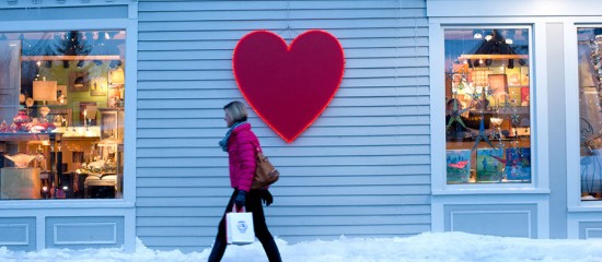 a person walking in front of a store with a heart sign