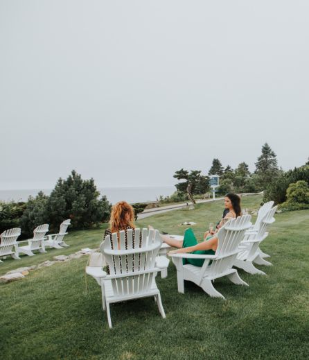 a group of people sitting in chairs on grass
