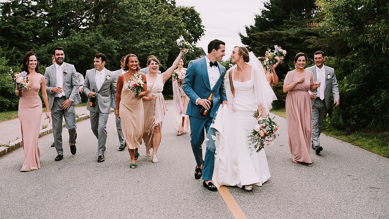 a bridal party walking down a road