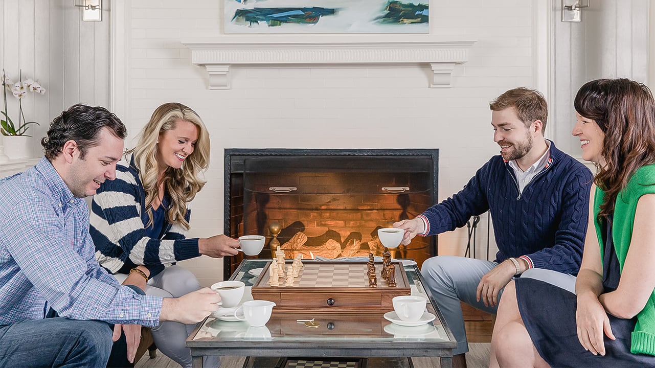 a group of people sitting around a table with cups and saucers