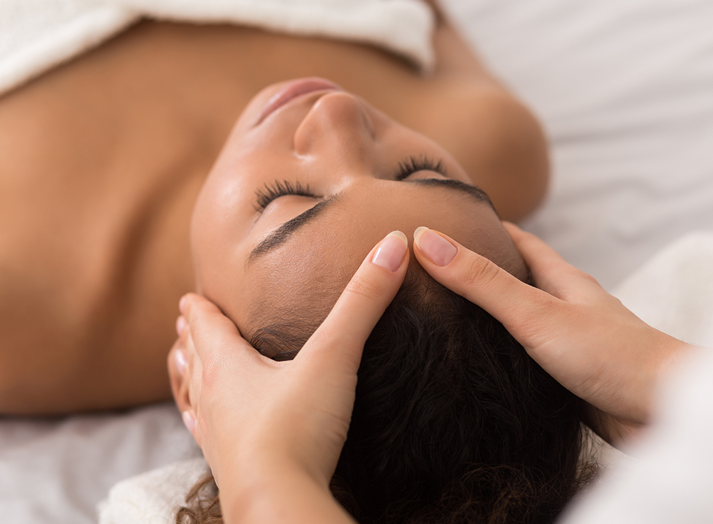 a woman lying on her back with her hand on her face Next