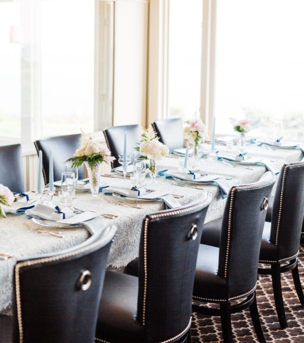 a dining table with chairs and flowers
