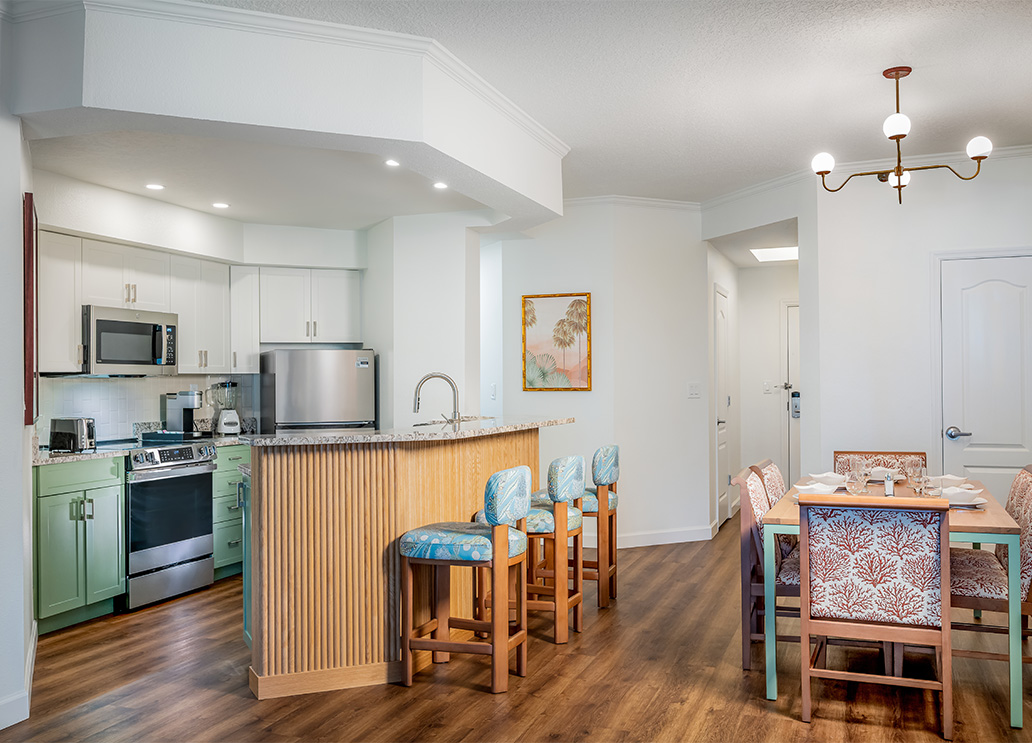 a kitchen and dining area with a bar and chairs
