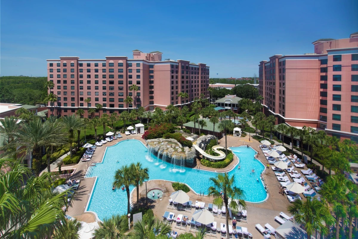 aerial image of the pool with green palm trees and a view of the buildings 