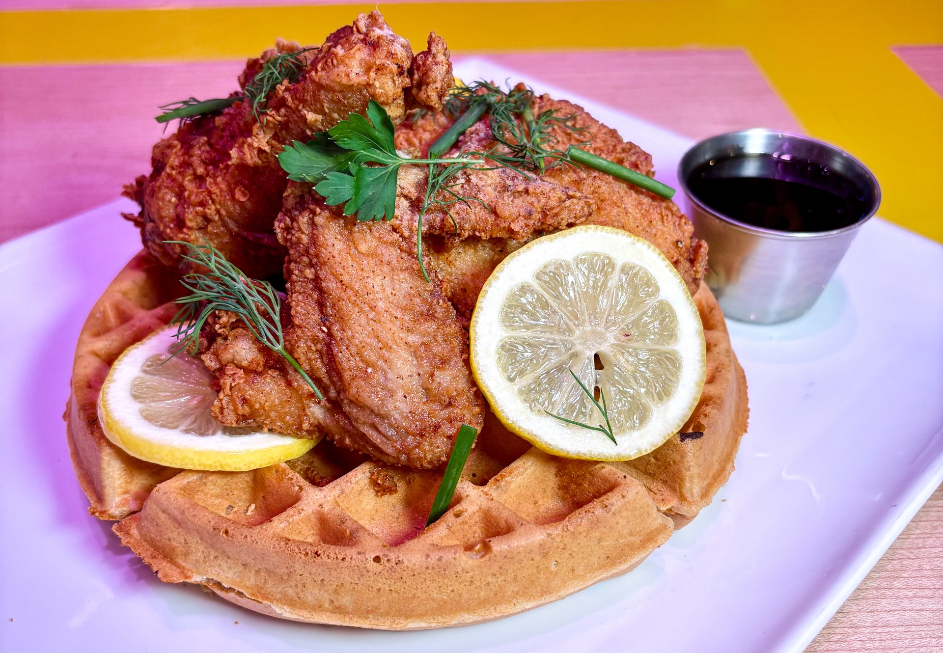 a plate of food with lemons and a cup of sauce