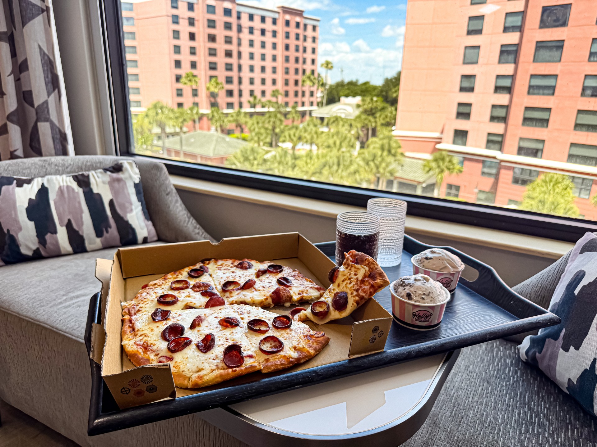 a pizza on a tray by a window