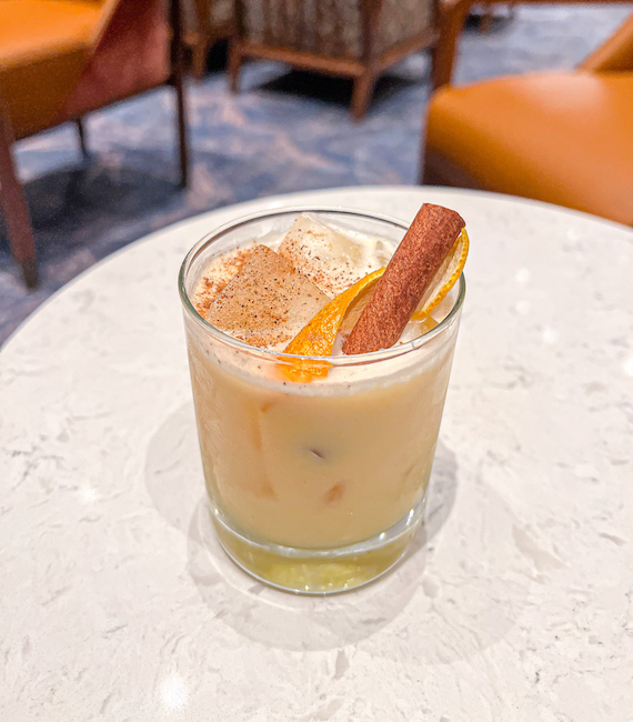 bombardino drink with a cinnamon stick and an orange peel