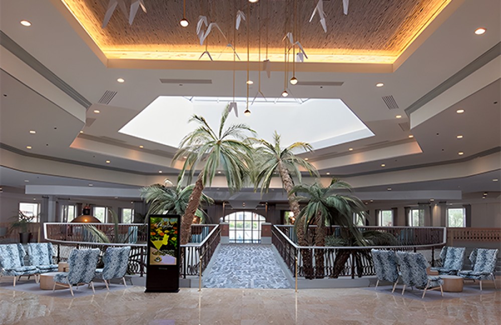 a large room with chairs and palm trees
