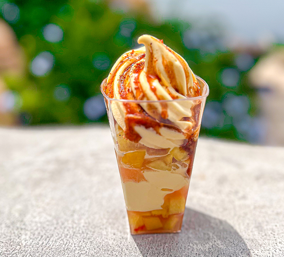 a cup of ice cream with fruit and toppings