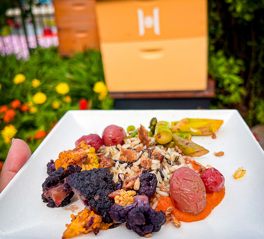 a plate of food with a hand holding a box