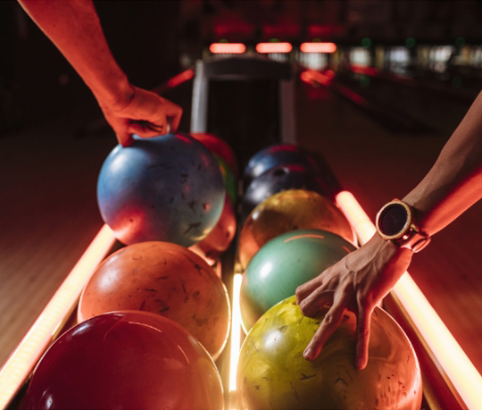 a bowling alley with a row of bowling balls