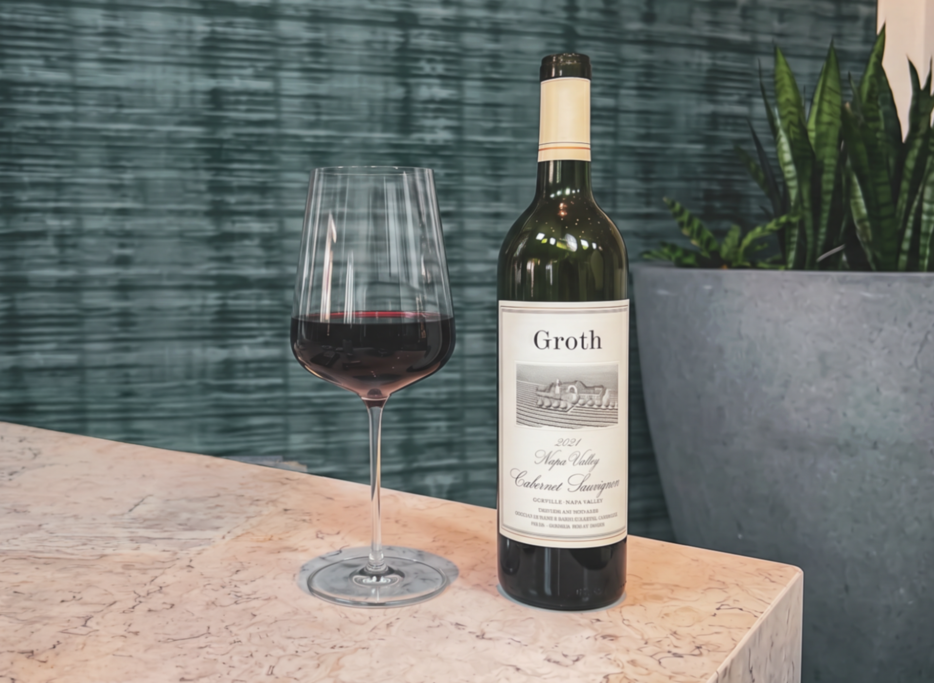 a bottle of wine next to a glass of wine
