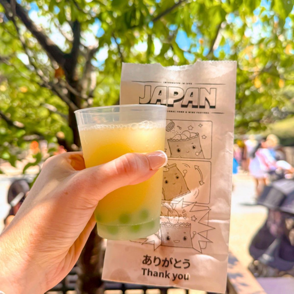 a hand holding a drink and a packet